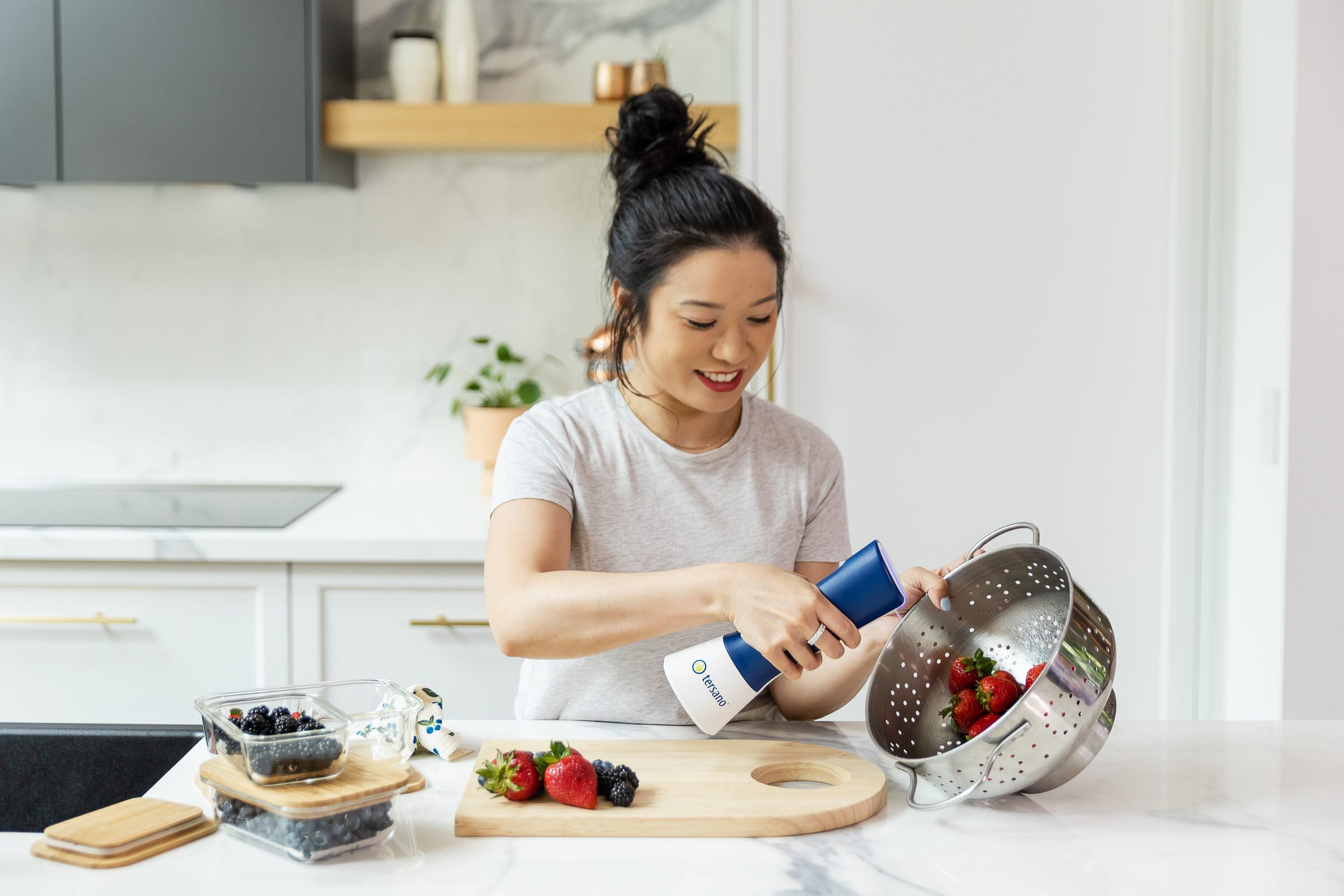 Persona lavando frutas con ozono acuoso iClean mini en su cocina