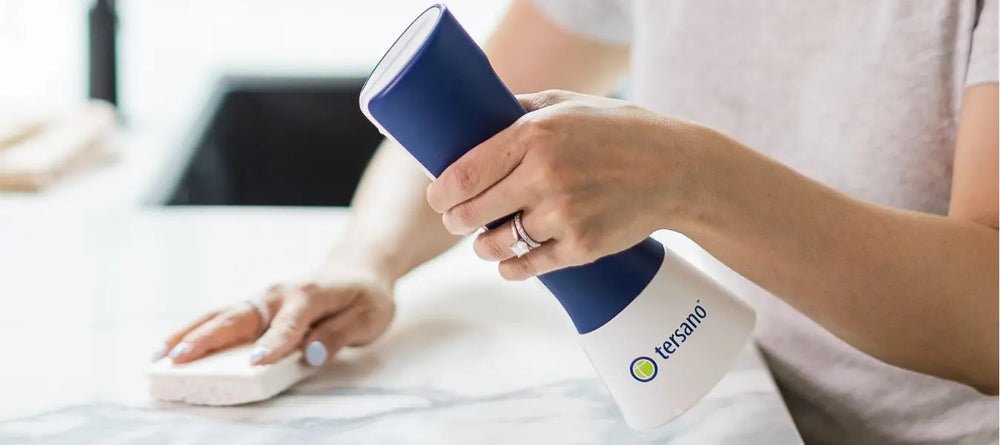 Persona sanitizando una encimera de mármol con iClean mini